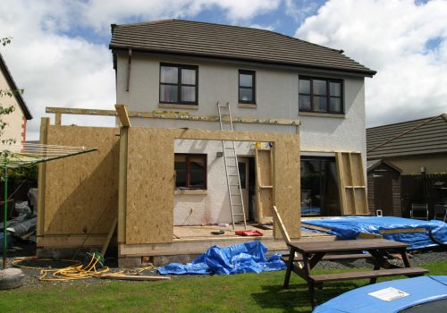 A modern home with an extension being built