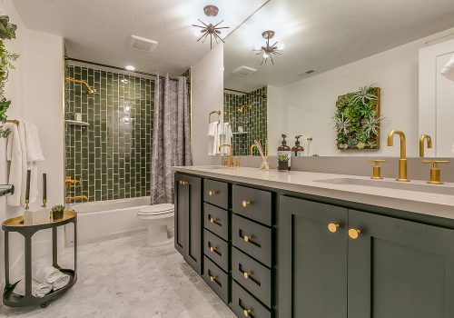 Green is the theme in this beautiful bathroom with brass faucets and fixtures